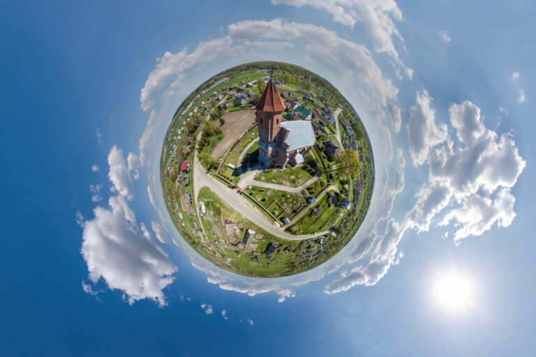 little planet transformation of spherical panorama 360 degrees overlooking church in center of globe in blue sky. Spherical abstract aerial view with curvature of space.